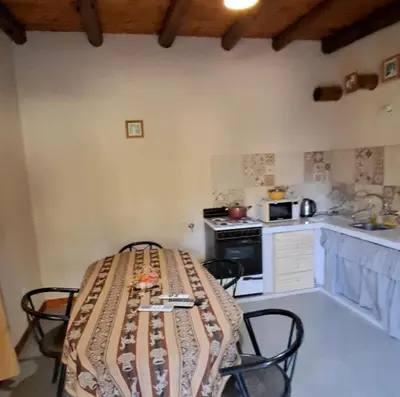 a kitchen with a table and chairs in a room at Cabaña EL AROMO in La Paz
