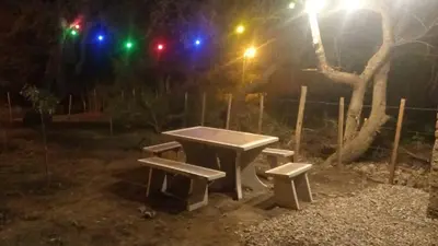 a picnic table and two benches at night at Cabaña EL AROMO in La Paz