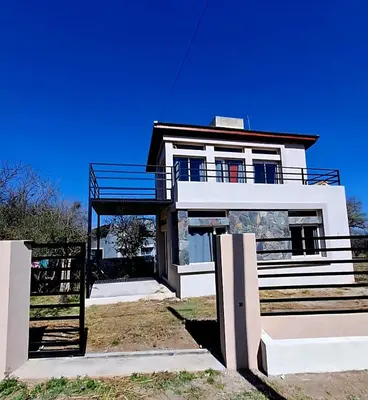 a large white house with a blue sky at Casa de la Sierras in Cerro de Oro