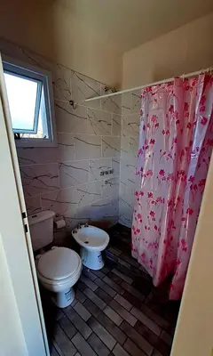 a bathroom with a toilet and a shower curtain at Casa de la Sierras in Cerro de Oro