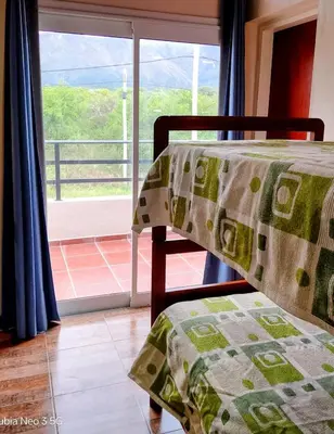 a bedroom with a bed and a window with a view at Casa de la Sierras in Cerro de Oro