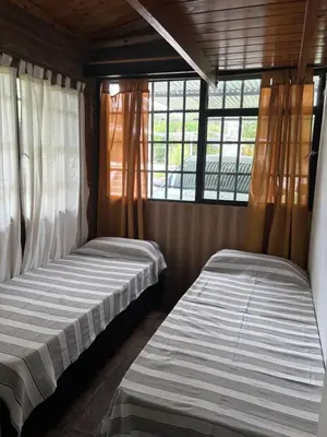 two beds in a small room with windows at Complejo Villa Lago in Villa Carlos Paz