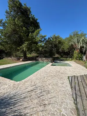a swimming pool in a yard with a tree at Complejo Villa Lago in Villa Carlos Paz