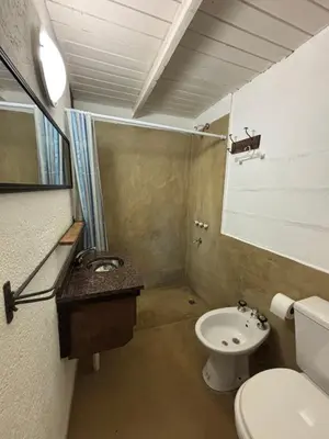 a small bathroom with a toilet and a sink at Complejo Villa Lago in Villa Carlos Paz