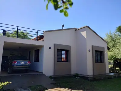 a car parked in front of a white house at Berna in Carpintería