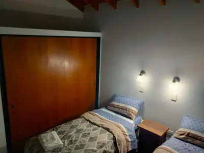 a bedroom with two beds next to a wooden door at Berna in Carpintería