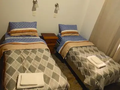 a bedroom with two twin beds and a night stand at Berna in Carpintería