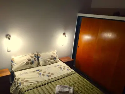 a bedroom with a bed and a wooden door at Berna in Carpintería