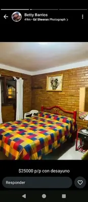 a bedroom with a bed with a colorful blanket at Hostería Huanel in Villa Cura Brochero