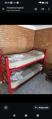 a small red bunk bed in a brick wall at Hostería Huanel in Villa Cura Brochero