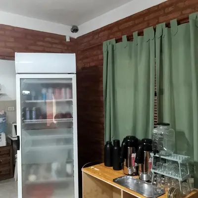 a kitchen with a green curtain and a refrigerator at Hostería Huanel in Villa Cura Brochero