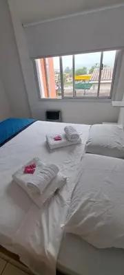 a white bed with towels on it with a window at Apartment Playas de Oro Villa Carlos Paz in Villa Carlos Paz
