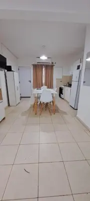 a large room with a table and some white appliances at Apartment Playas de Oro Villa Carlos Paz in Villa Carlos Paz