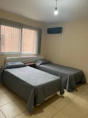 a bedroom with two beds and a fan at Confortable departamento en el centro de la ciudad in Cordoba