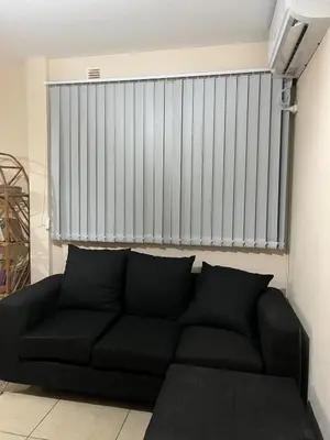a black couch in a living room with a wall at Confortable departamento en el centro de la ciudad in Cordoba