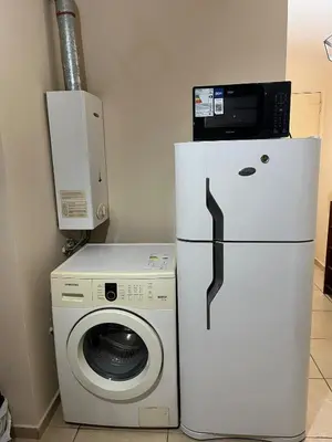 a refrigerator next to a washing machine and a microwave at Confortable departamento en el centro de la ciudad in Cordoba