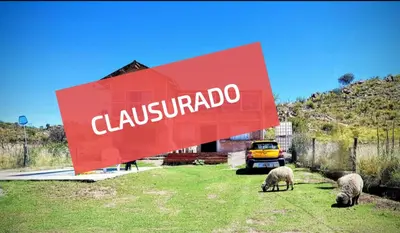 a sign with three sheep grazing in a field at Depa Temporario in Trapiche