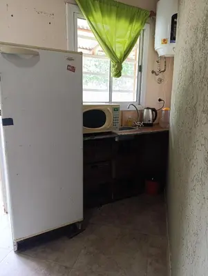 a kitchen with a white refrigerator and a microwave at Hostel 2 in Pilar