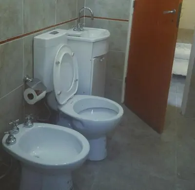 a bathroom with a white toilet and a sink at Hostel 2 in Pilar