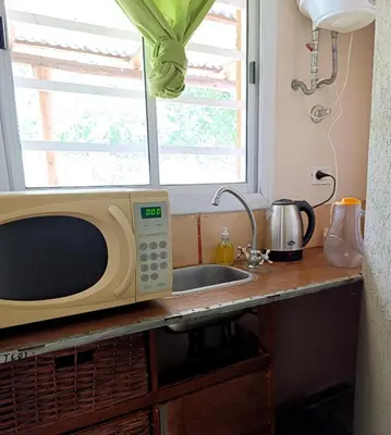 a kitchen counter with a microwave and a sink at Hostel 2 in Pilar
