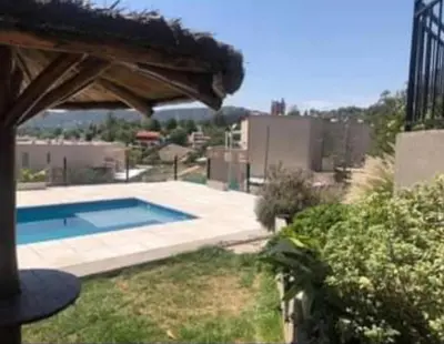 a swimming pool in a yard with a roof at Vito in Villa Carlos Paz