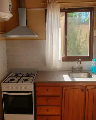 a kitchen with a stove and a sink and a window at Viva raíz in Nono