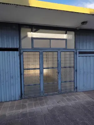 an empty garage with doors and windows on a building at Complejo MIAMI BEACH in Villa Carlos Paz