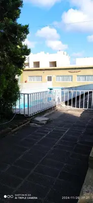 a building with a fence in a parking lot at Complejo MIAMI BEACH in Villa Carlos Paz