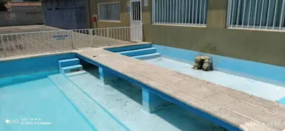 a dog sitting on a bench in front of a building at Complejo MIAMI BEACH in Villa Carlos Paz