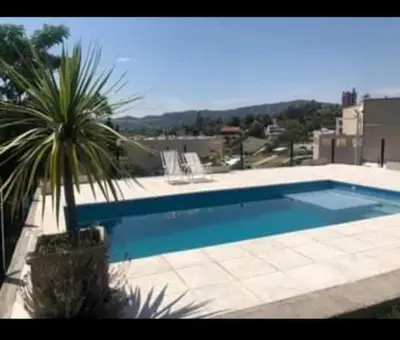 a large swimming pool with a palm tree next to it at Vito in Villa Carlos Paz