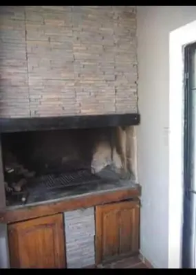 a kitchen with a counter with a brick wall at Vito in Villa Carlos Paz