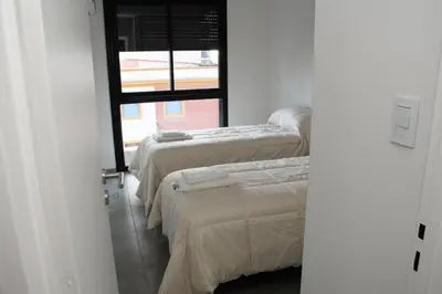 three beds in a room with a window at Hale Kalena in Cordoba