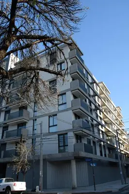 a tall white building with a car parked in front of it at Hale Kalena in Cordoba