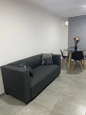 a black couch in a living room with a table at Hale Kalena in Cordoba