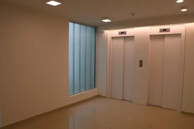 a hallway with three elevators and a large window at Hale Kalena in Cordoba