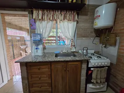 a kitchen with a sink and a stove and a window at Balcones del sol in Mina Clavero