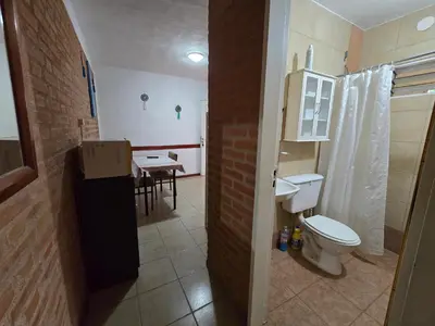 a bathroom with a toilet and a kitchen with a table at Balcones del sol in Mina Clavero