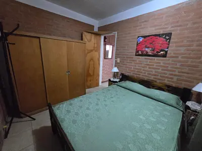 a bedroom with a bed and a brick wall at Balcones del sol in Mina Clavero