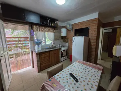 a kitchen with a table and a white refrigerator at Balcones del sol in Mina Clavero