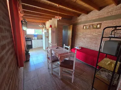 a small room with a table and a red couch at Balcones del sol in Mina Clavero