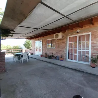 a patio with awning and a table and chairs at Balcones del sol in Mina Clavero