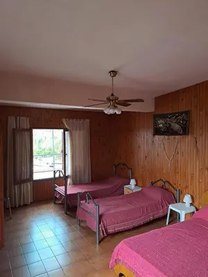 a bedroom with two beds and a ceiling fan at Complejo calle Córdoba in Mina Clavero