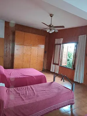 a bedroom with two beds and a ceiling fan at Complejo calle Córdoba in Mina Clavero