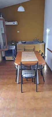 a kitchen with a table and chairs in a kitchen at Complejo calle Córdoba in Mina Clavero
