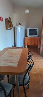 a dining room with a table and a refrigerator at Complejo calle Córdoba in Mina Clavero