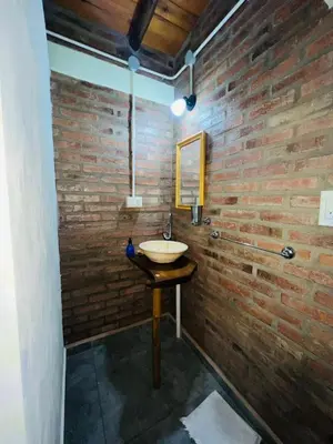 a bathroom with a sink and a brick wall at Monoambiente in Santa Rosa de Calamuchita