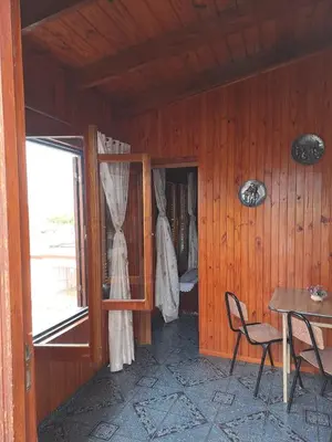 a wooden room with a table and chairs and a window at Departamentos Córdoba in Mina Clavero