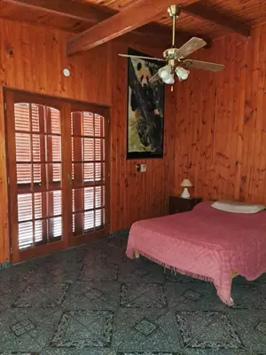 a bedroom with a bed and a ceiling fan at Departamentos Córdoba in Mina Clavero