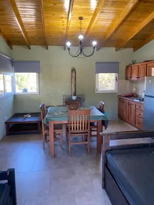 a kitchen with a table and chairs and a refrigerator at Tierra de Zorros in Cortaderas