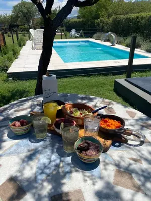 a table with bowls of food on a table near a pool at Tierra de Zorros in Cortaderas